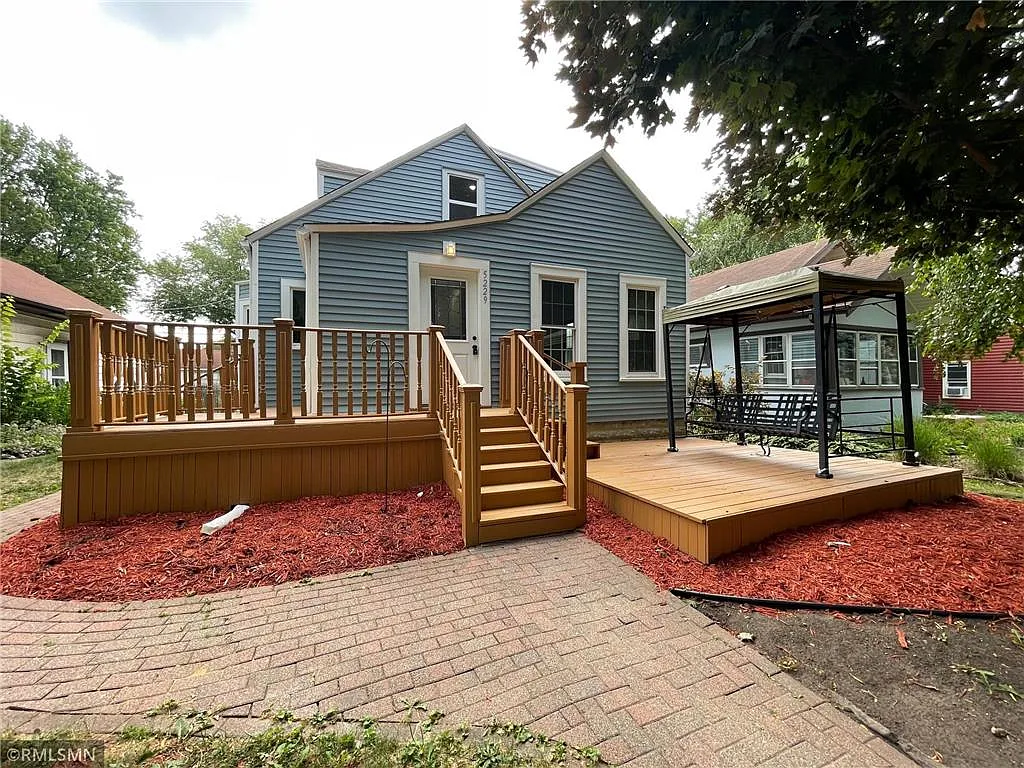 Exterior of Serenity Oaks — a welcoming home with a wraparound deck and pergola in Minneapolis, MN
